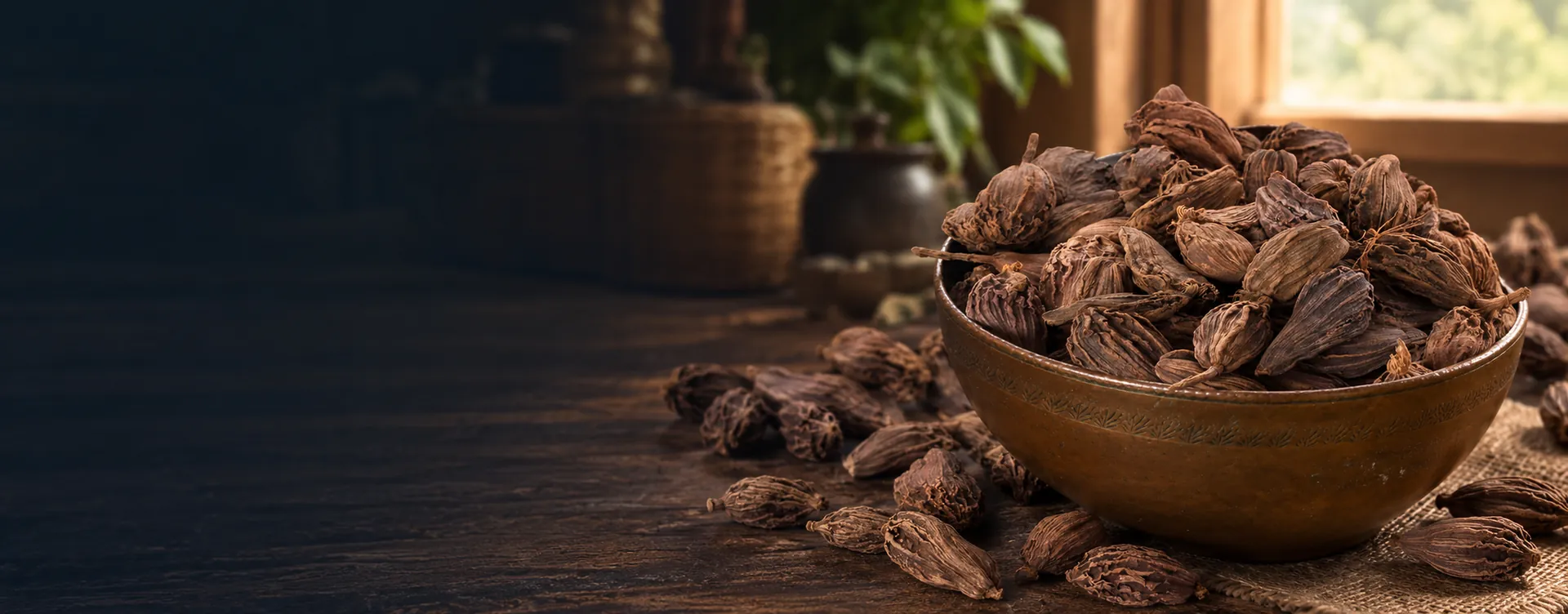 Nepalese black cardamom pods in a traditional bowl on a rustic kitchen table